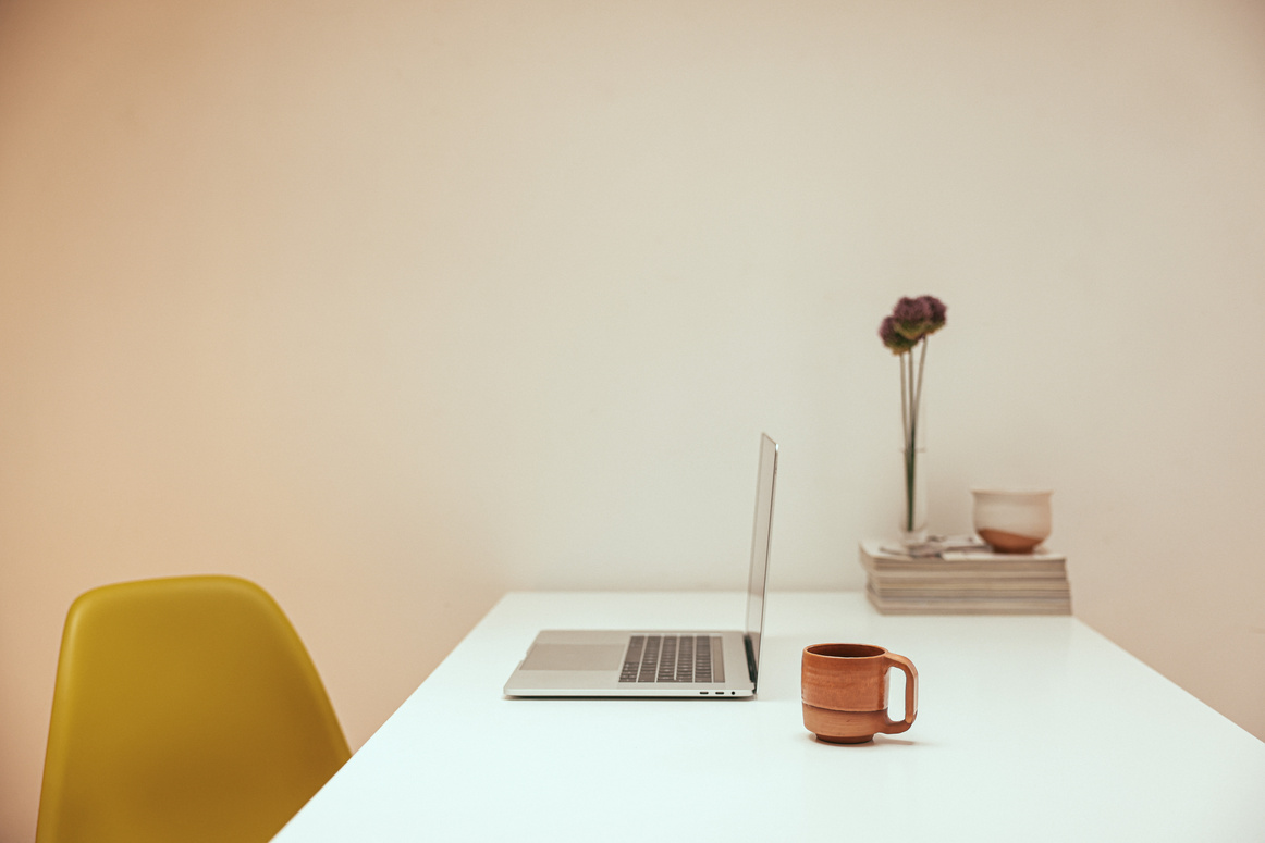 Side View of a Laptop and Cup of Coffee on a Table